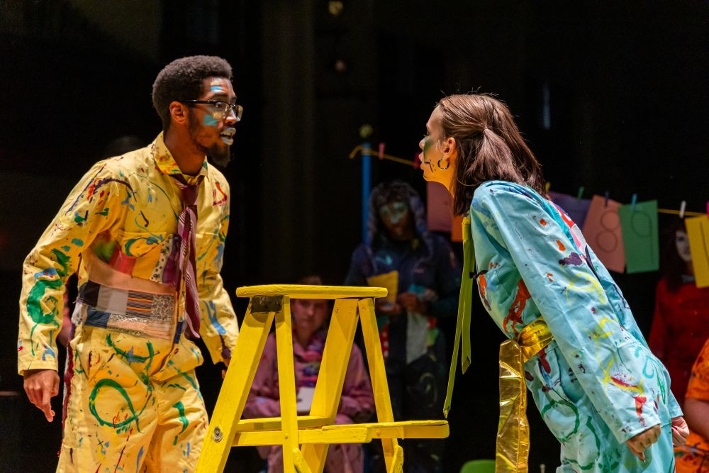 Two actors in bright colors yell at each other