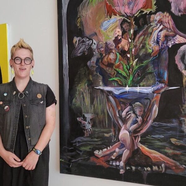 Aurora Powell standing in front of their art.