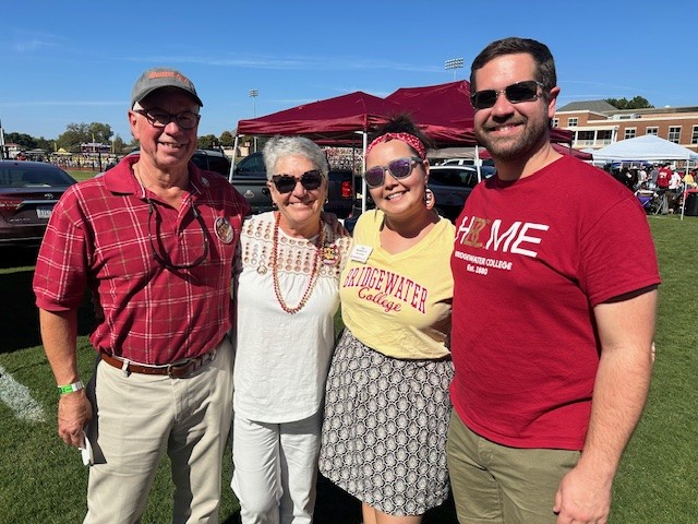 Tina and Paul stand with family at a tailgate