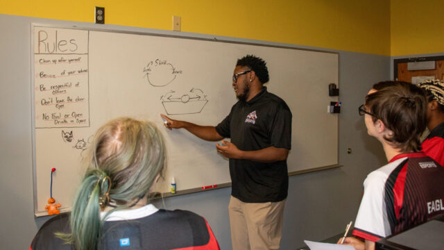 Coach Nyle illustrates game strategies on a whiteboard