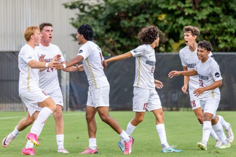 Men's soccer players celebrate a goal